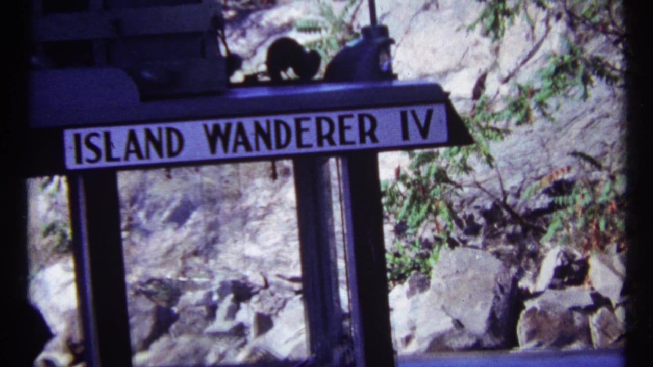 Island Wanderer IV sign and ferry structure with rocky shoreline behind.