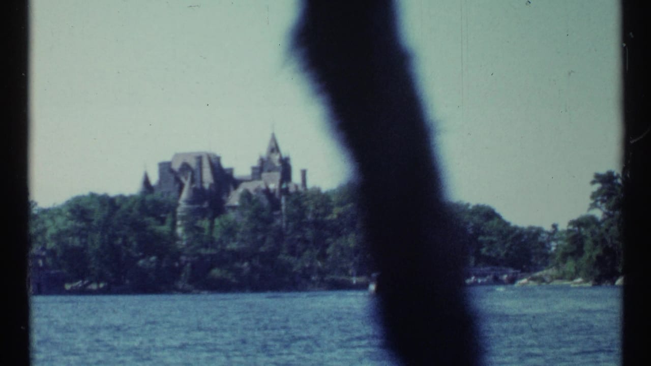 Distant castle-like building across water, partly obscured by a dark foreground shape.