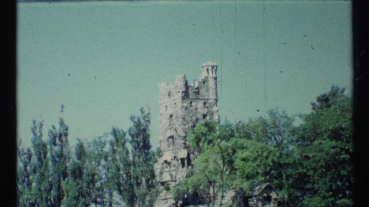 Toronto travel footage frame with a stone tower framed by tall trees and bright sky, shot on 8mm film in 1967.