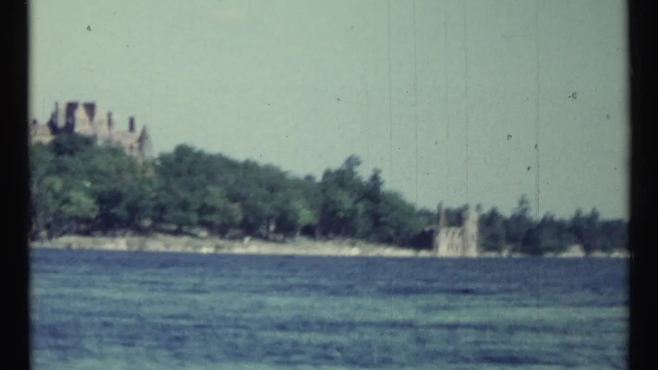 1967 Toronto lakeside view showing estate structures partly obscured by trees across the water.