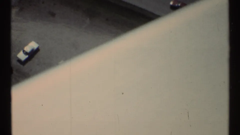 A high-angle 1967 Toronto view shows a small parked car and asphalt surface beyond the pale diagonal edge of the viewing structure.