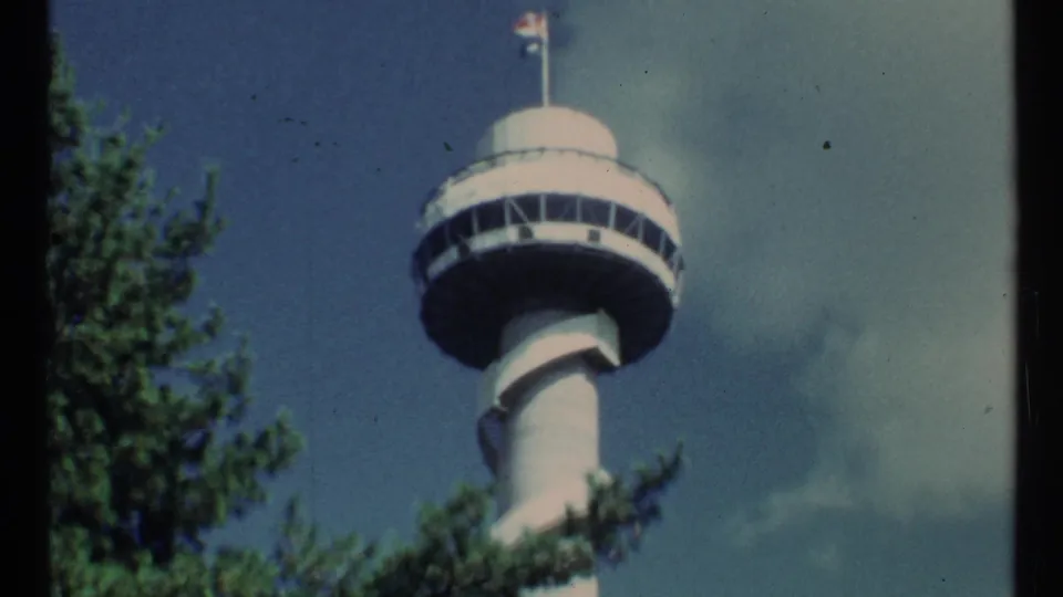 A 1967 Toronto frame shows a tall observation tower with a Canadian flag, trees in the foreground, and blue sky with light clouds.