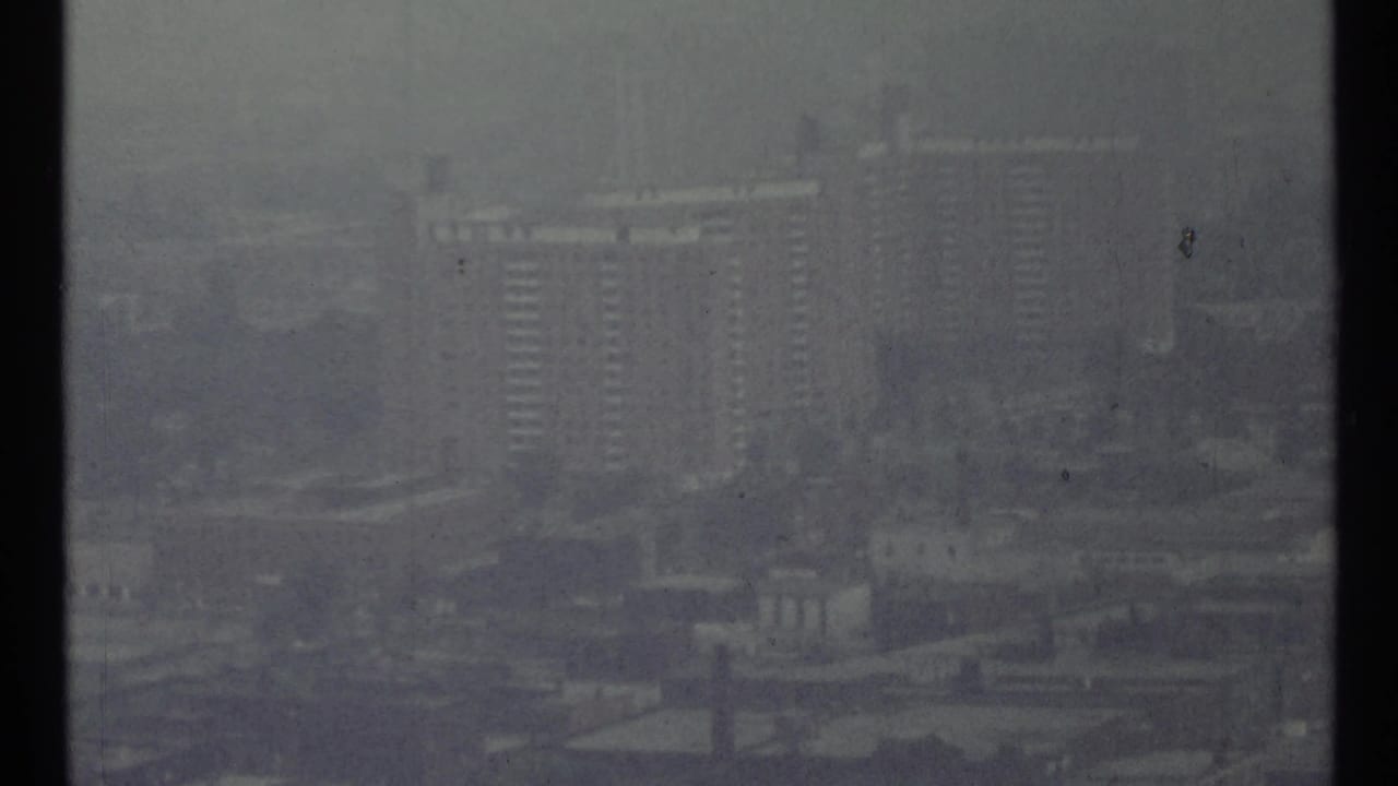 Hazy skyline with tall apartment buildings seen through fog.