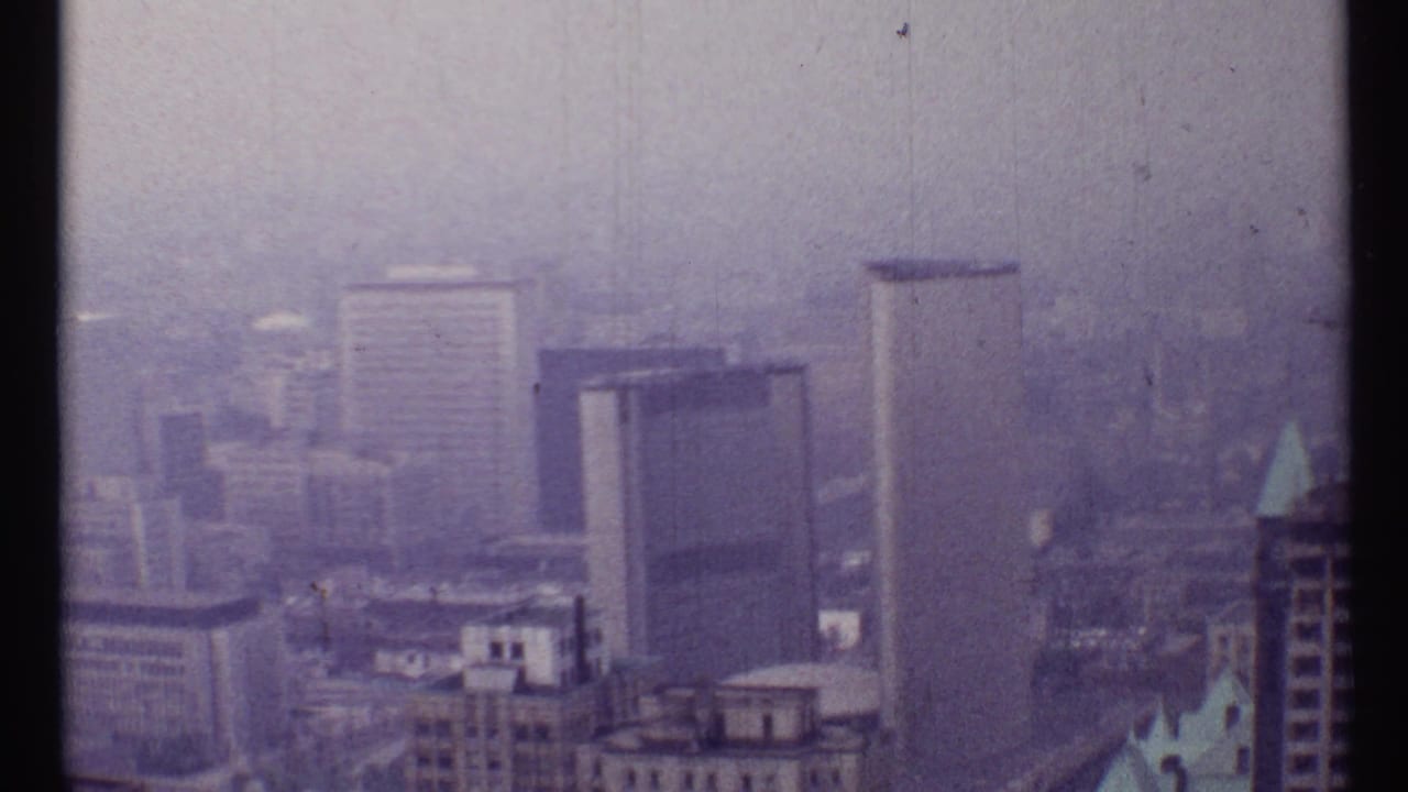 1967 Toronto skyline in hazy light, with mid-century high-rises and soft purple 8mm film color.