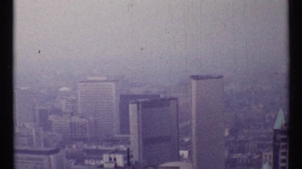 Downtown Toronto high-rises appear through haze in this 1967 8mm cityscape frame.