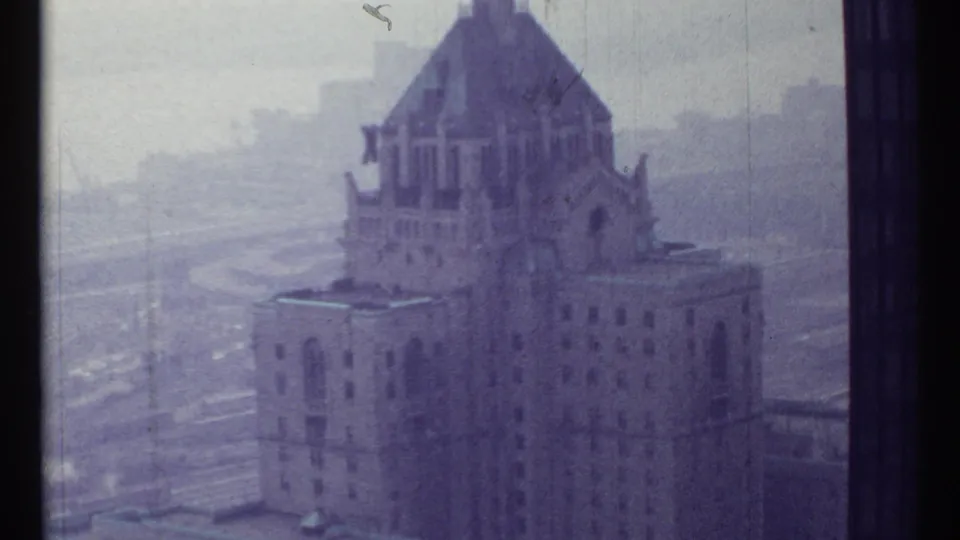 Soft 1967 Toronto frame showing the same ornate tower with arched architectural details, surrounded by haze and distant streets.