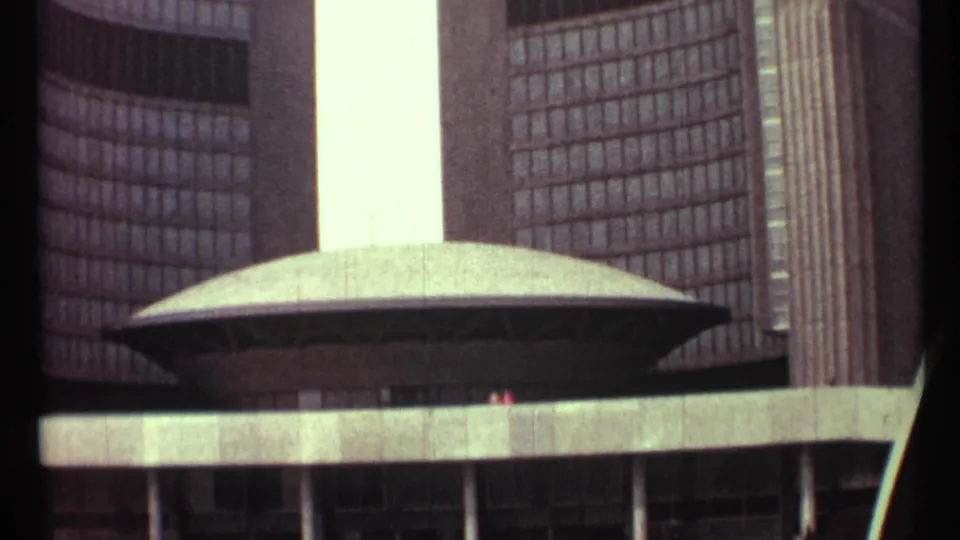 1967 Toronto City Hall detail with the central oval chamber roof framed by curved tower windows and concrete plaza structure.