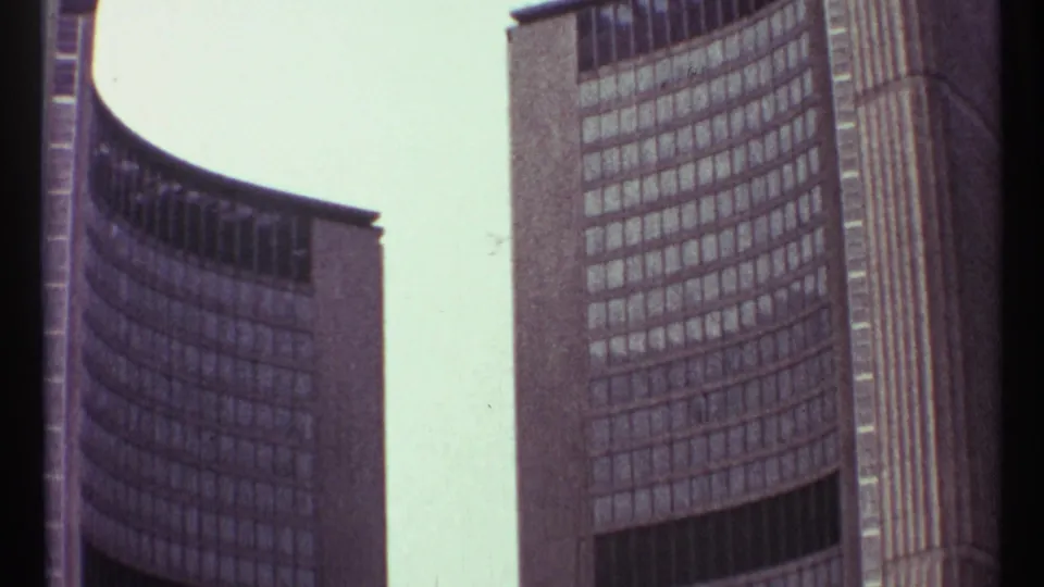 A 1967 Toronto frame of curved modernist architecture, with soft 8mm texture and repeating windows across the towers.