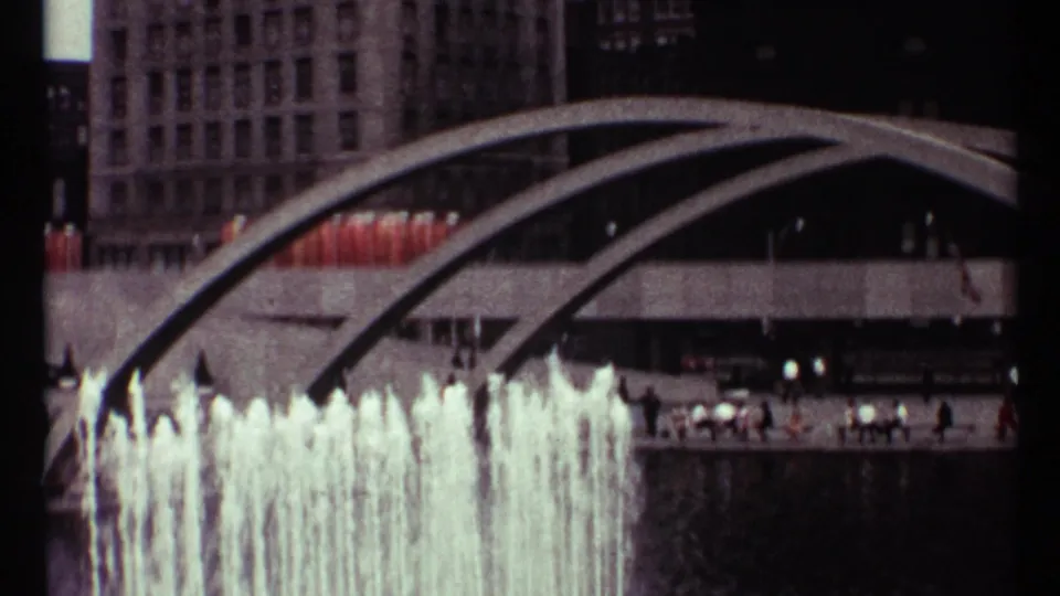 Wider 1967 Toronto view of fountain jets beneath curved modern beams, with people visible along the plaza level.