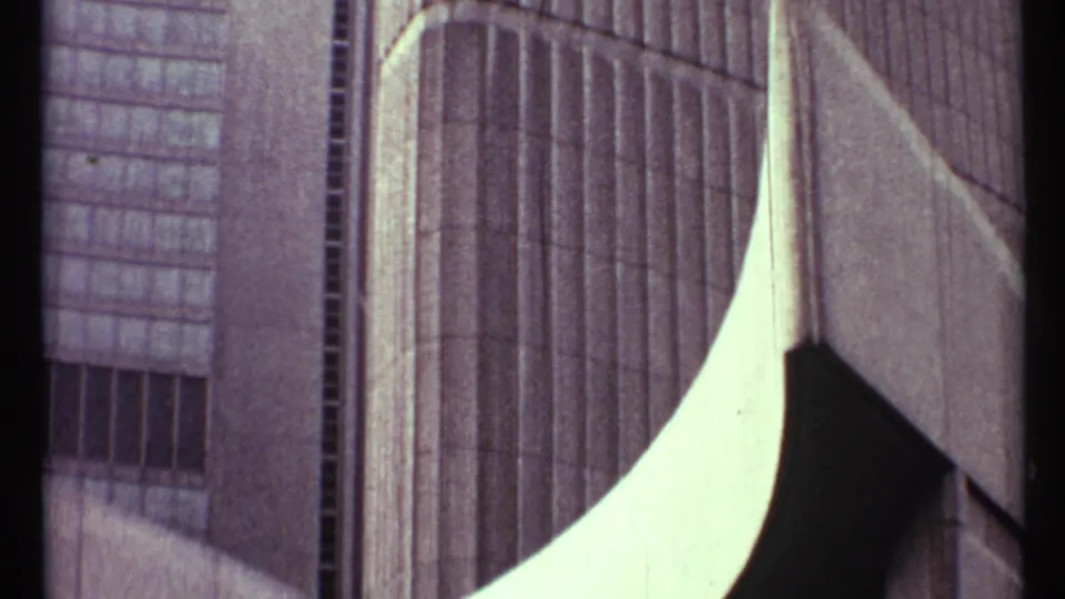 Low-angle 1967 Toronto view of a modernist high-rise facade with vertical window bands and curved pale concrete shapes.