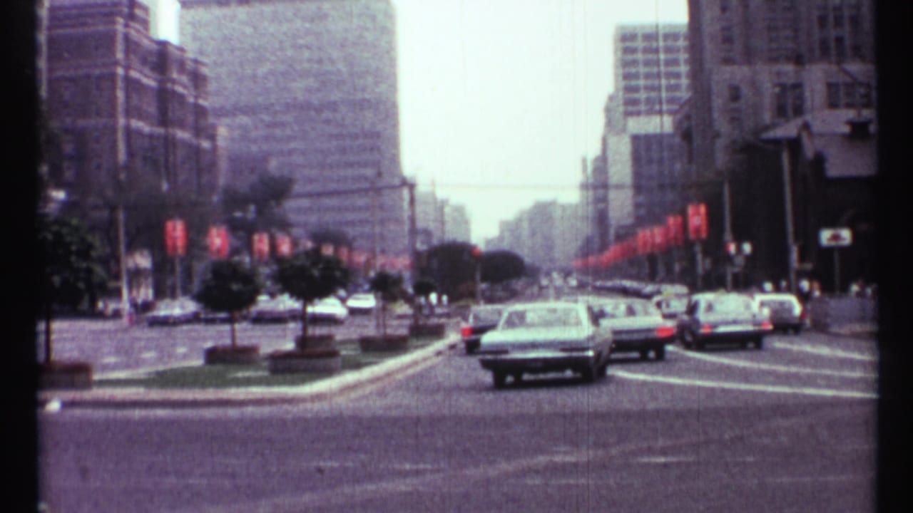 Downtown Toronto street with cars, planted median trees, and tall buildings.