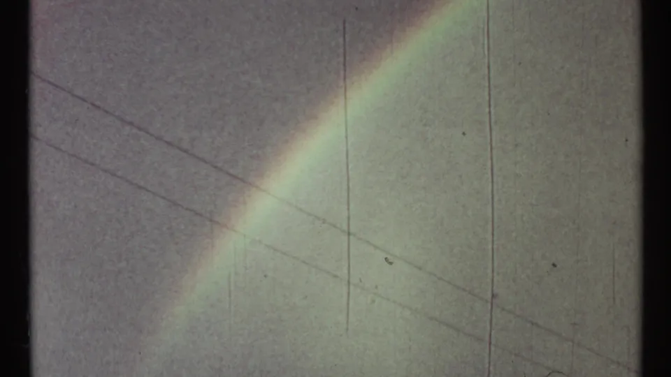 A muted 1967 Toronto sky shows a fading rainbow, thin utility lines, and soft 8mm film texture.