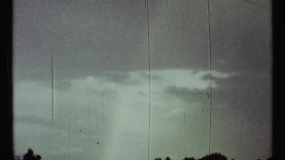 Pale rainbow segment over a rural horizon near Toronto, Canada metadata, with silhouetted trees and cloudy sky.