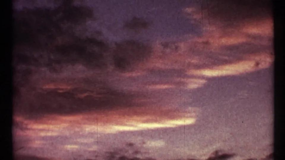 1967 Toronto 8mm sunset frame with pink, orange, and purple cloud bands over a dark foreground edge.