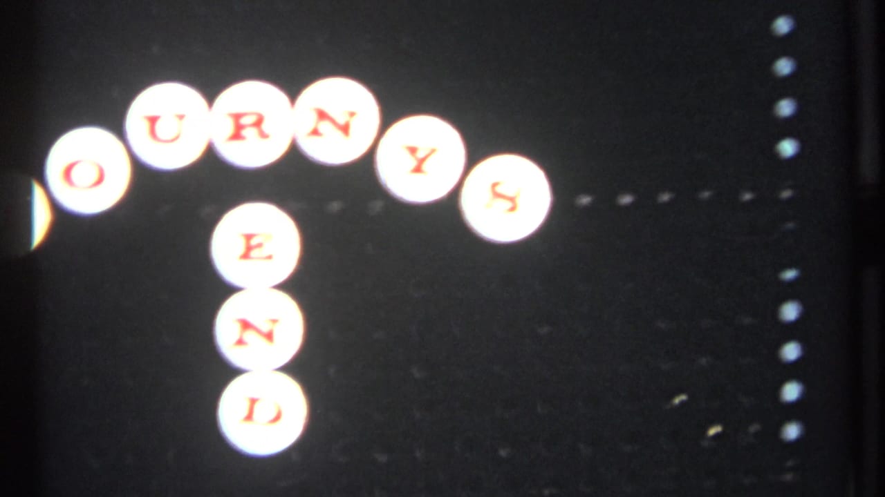 Partial JOURNEYS END sign made from white circular tiles with red letters on a dark background.