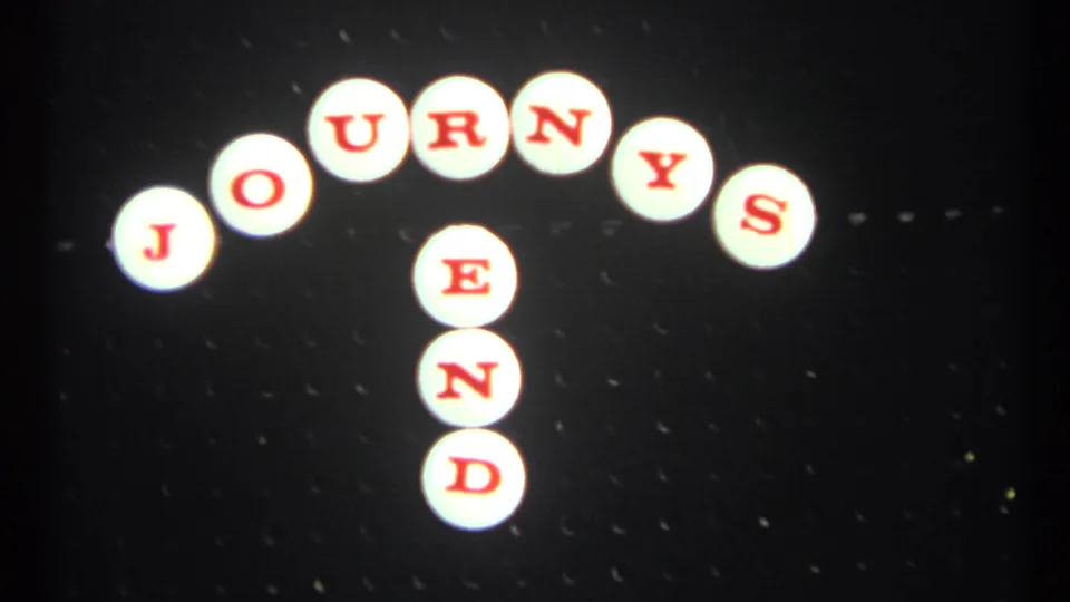 1967 Toronto 8mm frame of the JOURNEYS END sign, with red letters on white circles against a dark background.