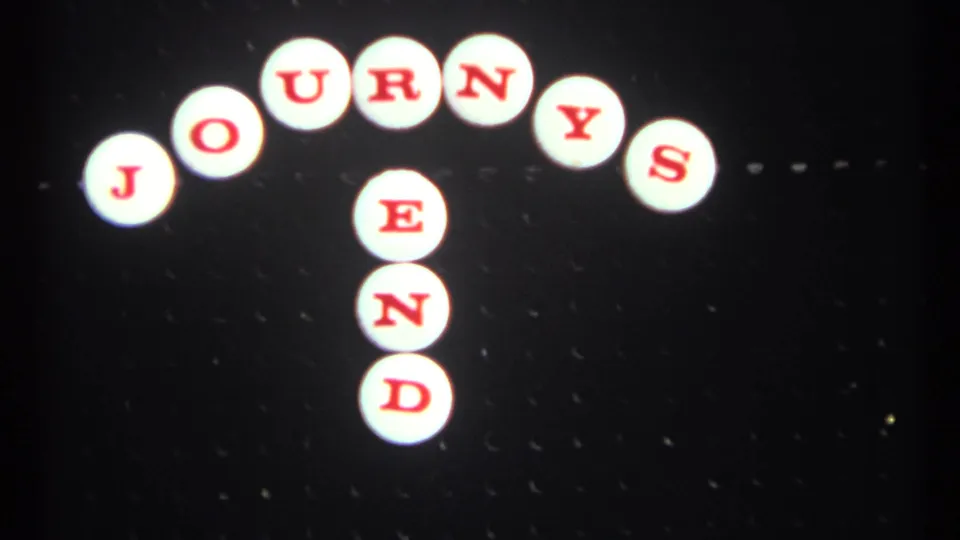 1967 Toronto 8mm frame of the JOURNEYS END sign near center, with bright white tiles and red lettering.