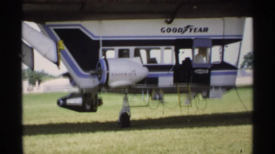 1970 Minnesota 8mm frame showing the Goodyear blimp parked on grass, with AMERICA lettering, gondola, and landing gear visible.