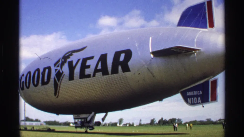 1970 Minnesota frame of the Goodyear blimp America N10A on grass, shot from close range with visitors nearby.