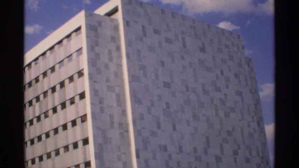 1970 Minnesota 8mm frame concentrating on the high-rise facade, with narrow window rows along one side.