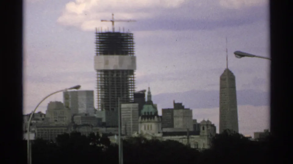 A 1970 Minnesota skyline view centers on a high-rise under construction with a crane above nearby buildings.