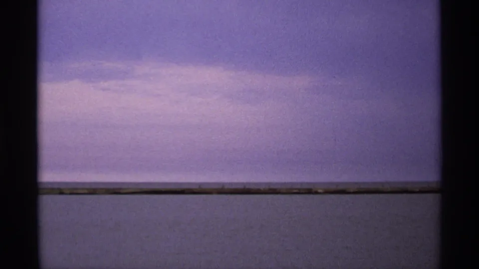 1971 Isle Royale 8mm frame showing open lake water beneath a purple evening sky, with dark film gate edges visible.