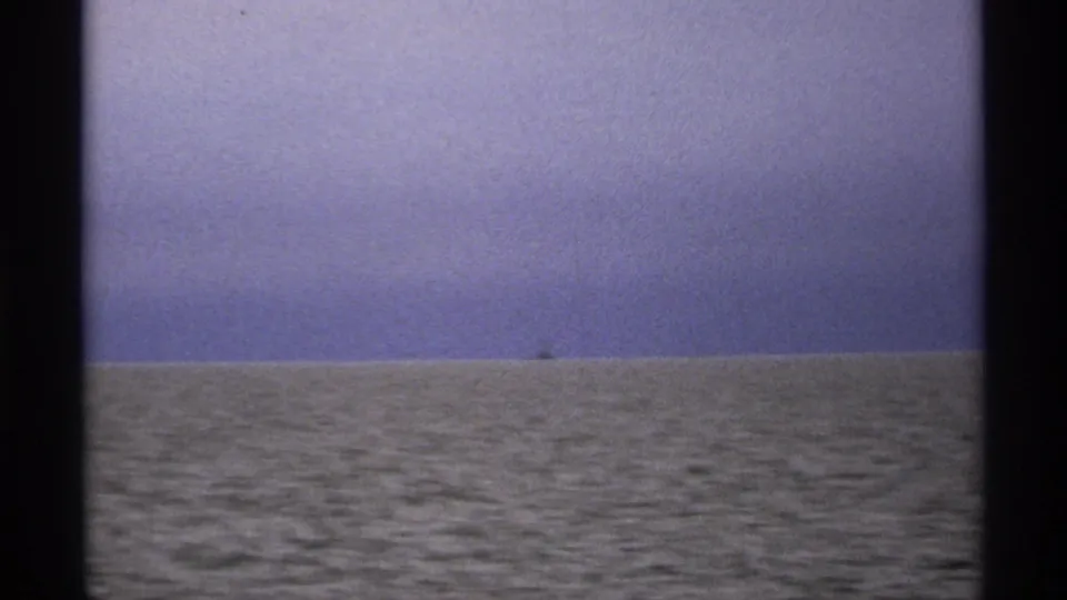 1971 8mm lake horizon near Isle Royale, with textured water, faded color, and dark frame edges from the film scan.