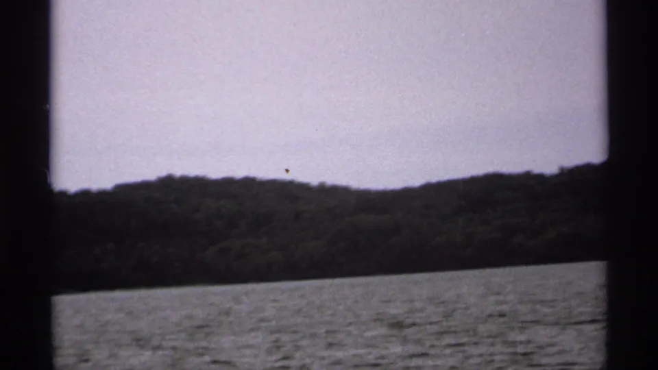 1971 Isle Royale frame with a distant tree-covered shoreline across the lake, bordered by the scanned film contact layout.