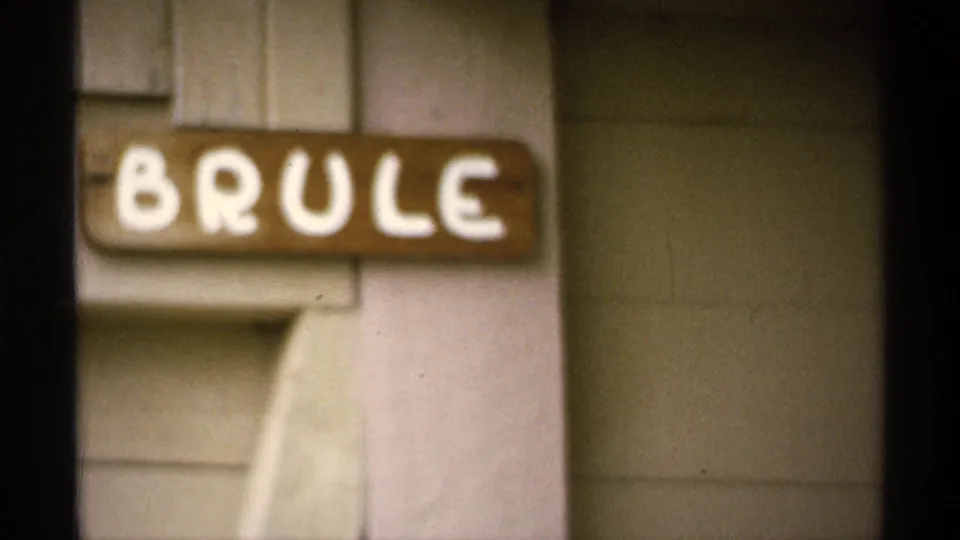 Soft 8mm close-up of the BRULE cabin sign and exterior siding at Isle Royale, Michigan, in the 1971 home movie.
