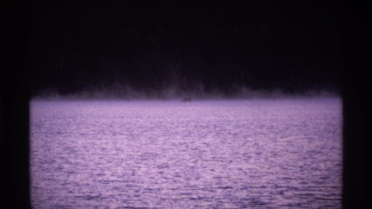 Misty lake water with a dark tree line and black 8mm frame border.