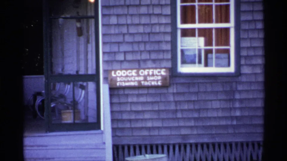 Lodge office sign for souvenirs and fishing tackle on a shingled Isle Royale building exterior in 1971.