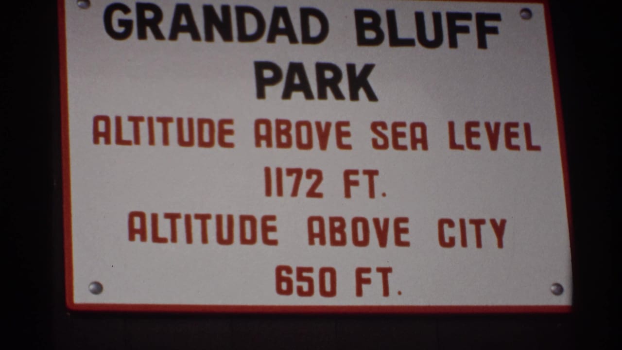 Close view of the Grandad Bluff Park altitude sign with red and black lettering.