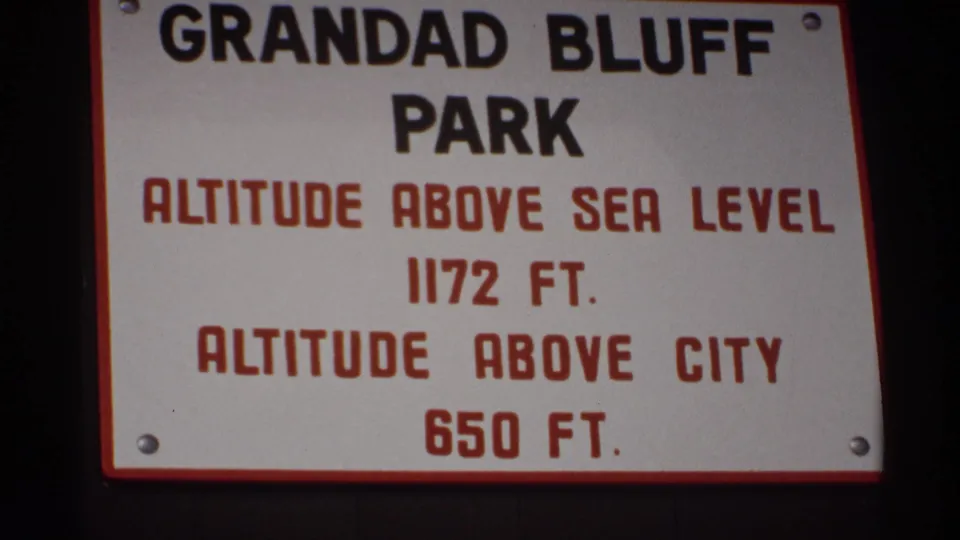 1971 La Crosse home-movie frame showing the Grandad Bluff Park sign listing altitude above sea level and city.