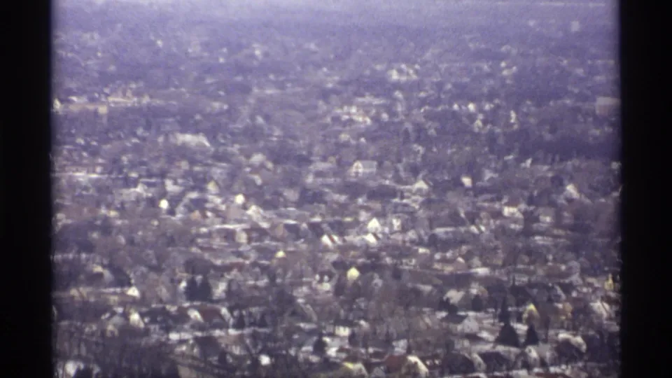 1971 La Crosse aerial frame looking over dense residential blocks, winter trees, and light-colored rooftops.