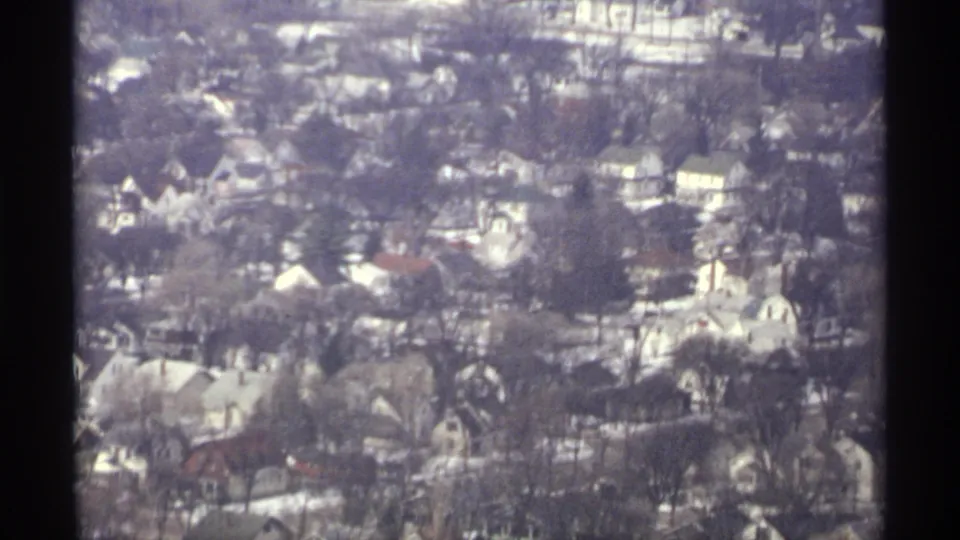Closer 1971 aerial frame of La Crosse homes, bare trees, small roads, and snow traces in a residential area.