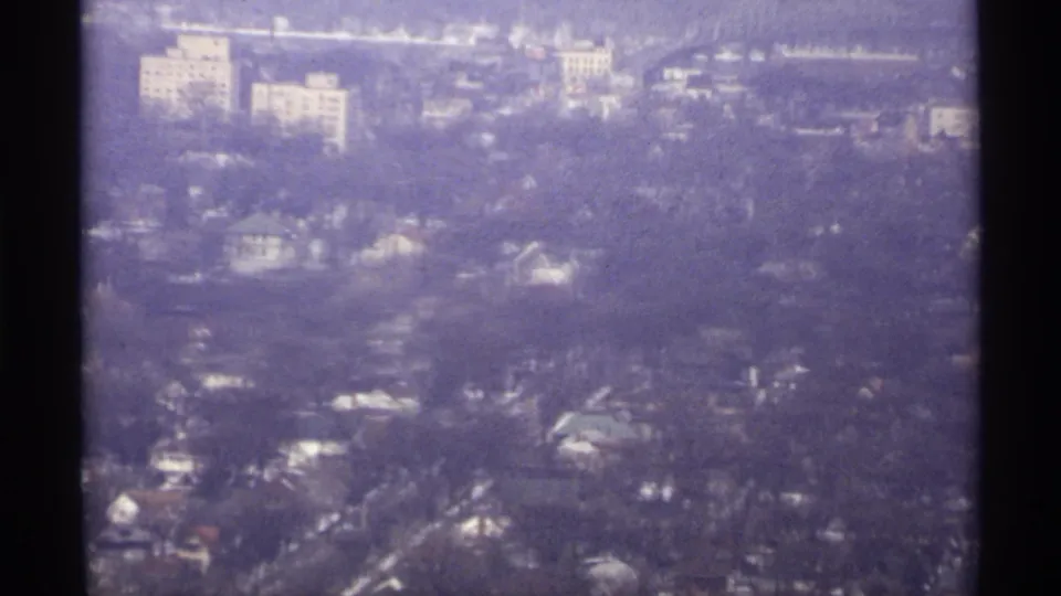 1971 La Crosse aerial view with tree-lined residential areas, roads, and pale larger buildings near the upper frame.