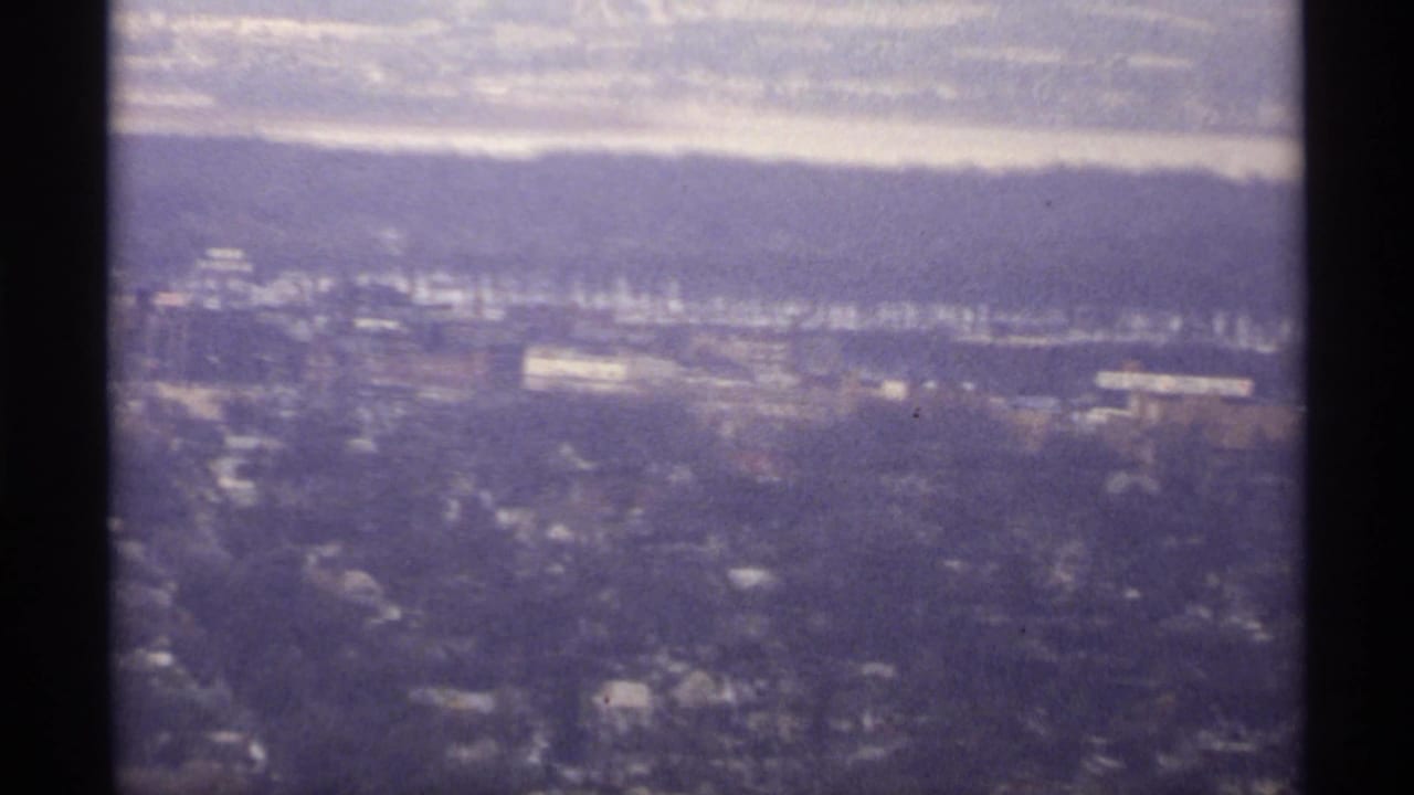 Elevated 1971 La Crosse view across snowy neighborhoods toward a river or lake and distant bluffs.