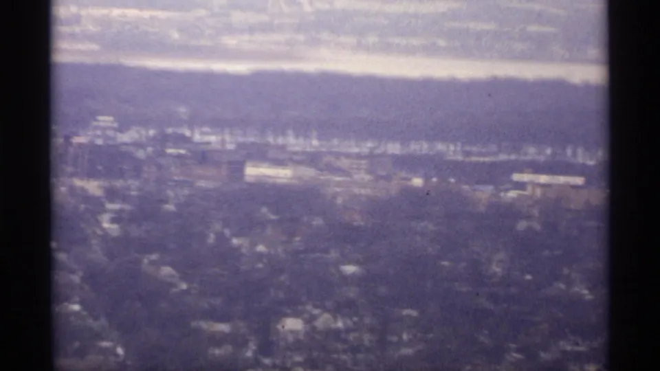 Elevated 1971 La Crosse view across snowy neighborhoods toward a river or lake and distant bluffs.
