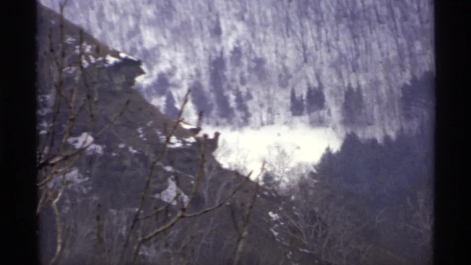 1971 La Crosse, Wisconsin frame with a snow-dusted hillside, bare branches, and dark 8mm frame edges.