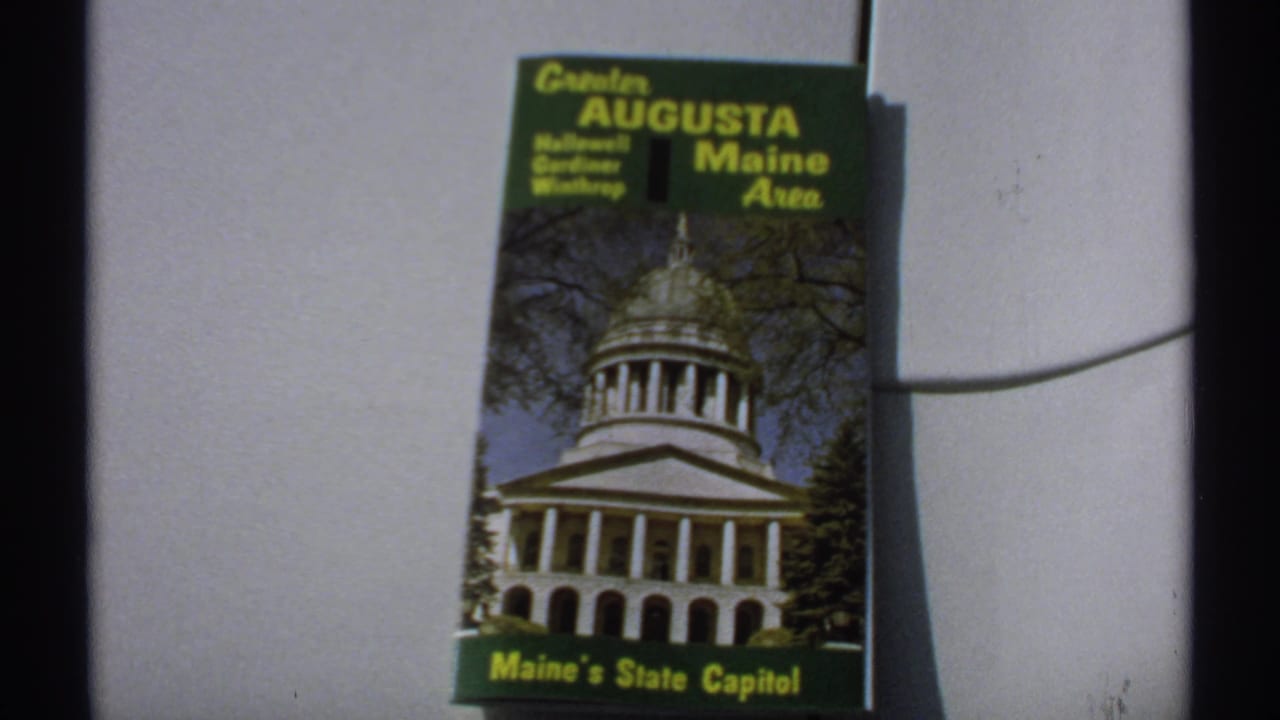 Greater Augusta Maine Area brochure with capitol photograph, framed beside a dark film edge.
