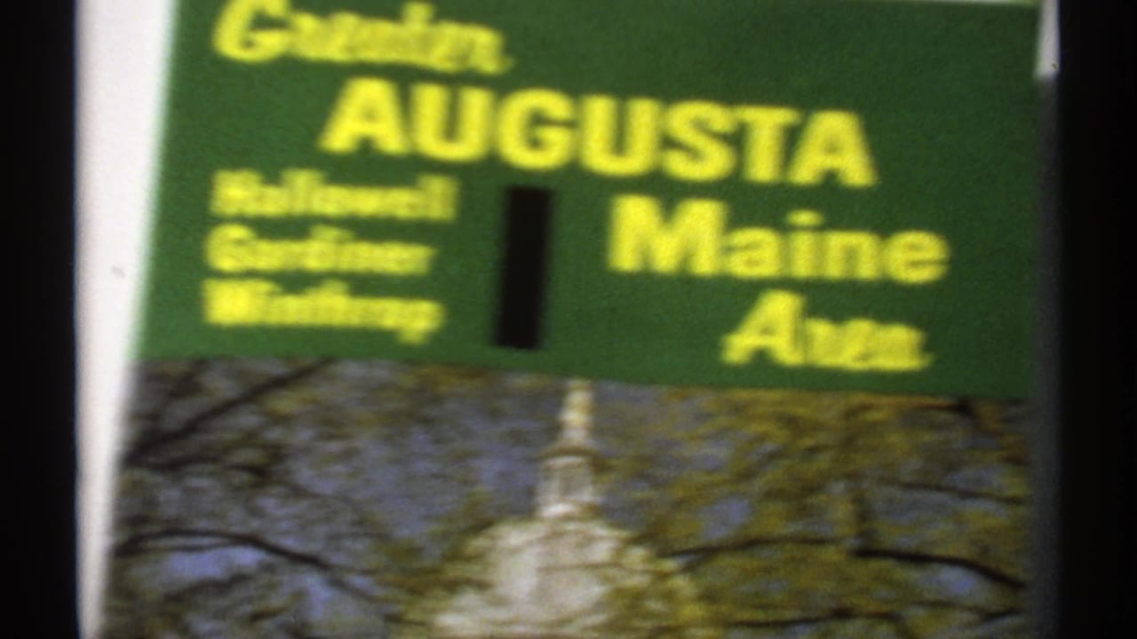 Soft-focus Augusta Maine sign above a partial capitol photograph or view.