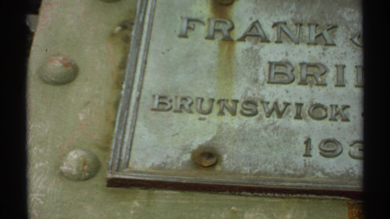 1971 Maine 8mm frame showing a weathered plaque with partial Frank J. Bridges and Brunswick text on a rusted green metal surface.