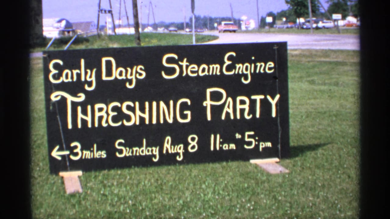 1971 Minnesota home-movie frame of the Early Days Steam Engine Threshing Party sign, listing Sunday, August 8, 11 am to 5 pm.