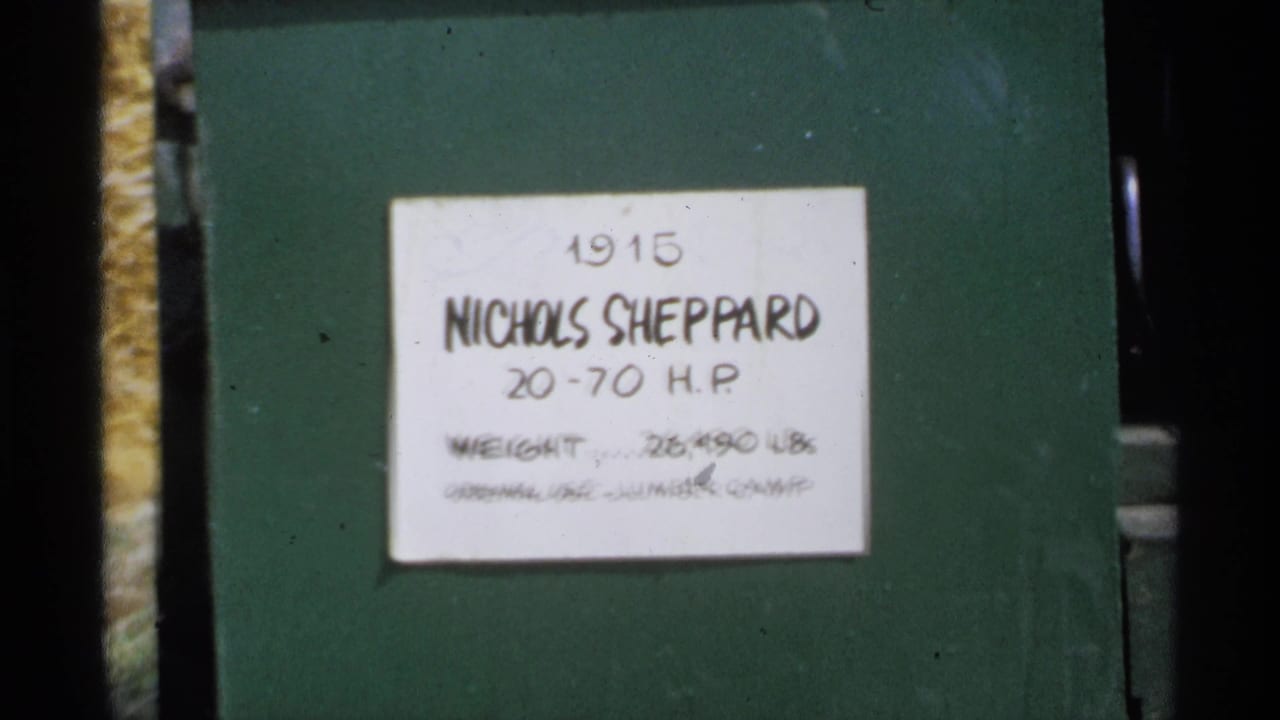 Close view of a handwritten placard on green machinery reading Nichols Sheppard 20-70 H.P.