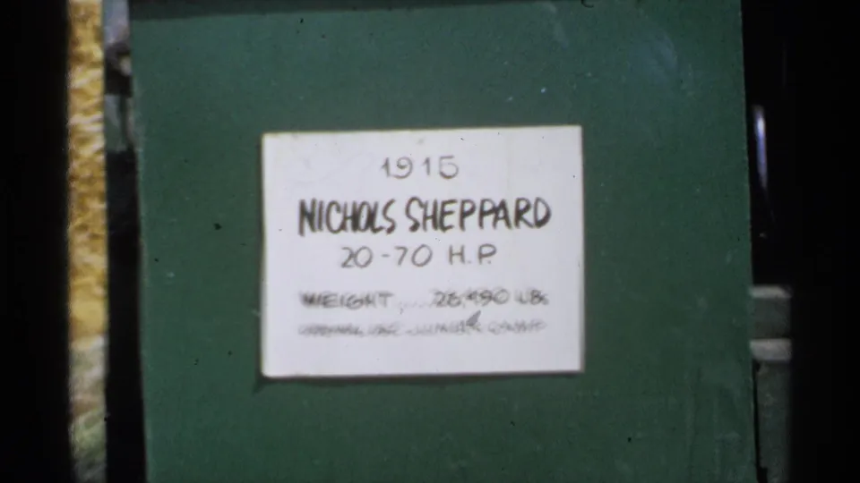 Minnesota 1971 8mm frame showing a handwritten Nichols Sheppard 20-70 H.P. placard attached to green machinery.