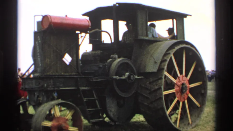 1971 Minnesota 8mm frame showing a dark steam tractor with a red tank, large spoked wheel, and an operator near the cab.