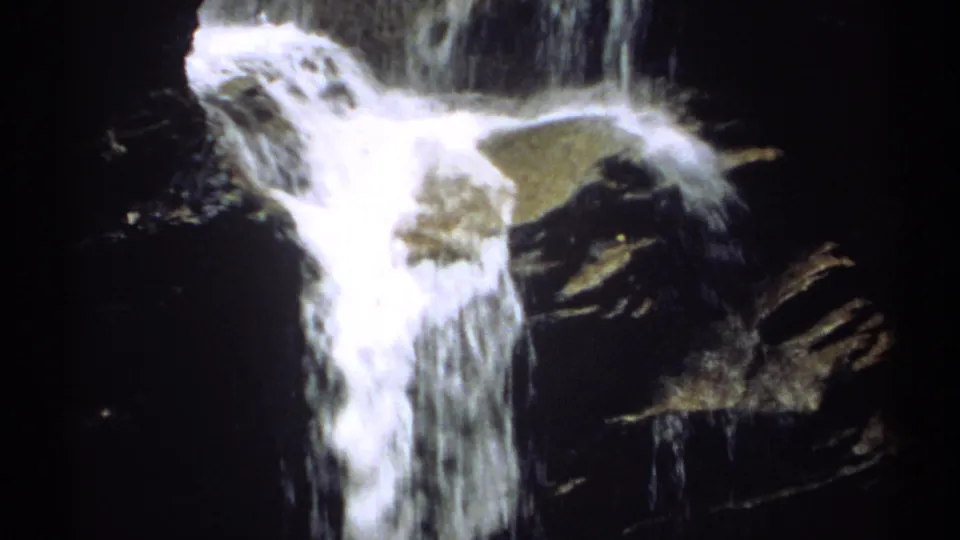 1971 New Hampshire 8mm frame capturing bright waterfall foam and dark rock textures near the end of the short clip.