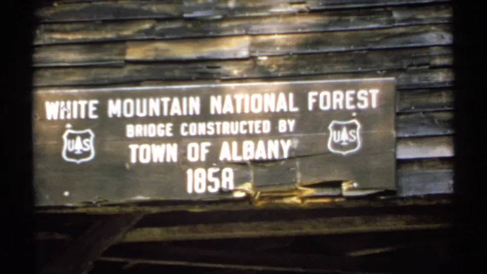 Close view of a White Mountain National Forest sign stating the bridge was constructed by the Town of Albany in 1858.