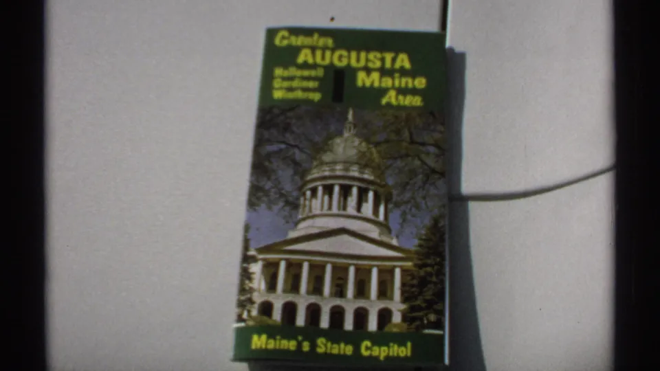 Close view of the green and yellow Greater Augusta Maine Area brochure, with Hallowell, Gardiner, and Winthrop listed on the cover.