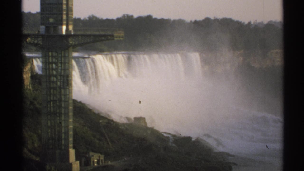 Niagara Falls with mist and a foreground observation tower seen through 8mm film borders.